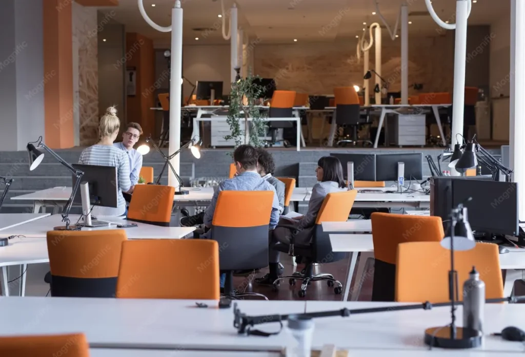 Open workspace with orange chairs and desk lamps